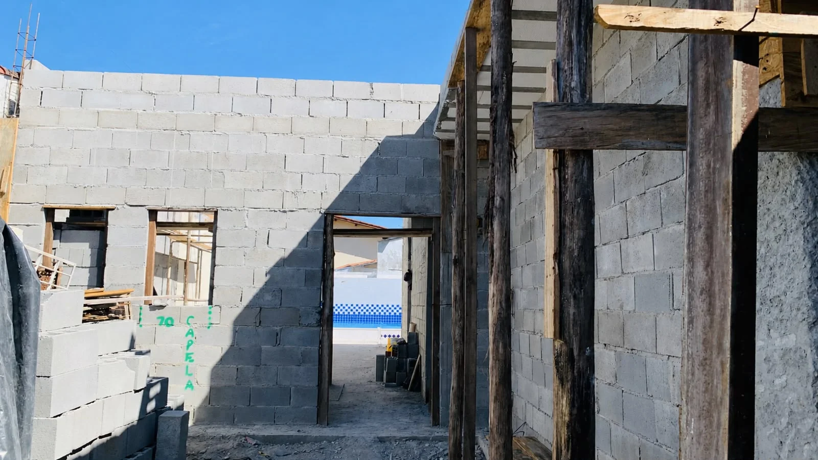Obra em andamento com paredes de alvenaria e estrutura em execução